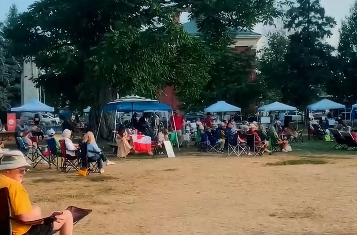 Families gathered under shade at a community park event